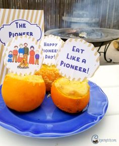 two oranges sitting on a blue plate with signs