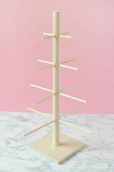 a white wooden stand with sticks sticking out of it's sides on a marble surface