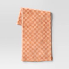 an orange checkered towel hanging on a wall