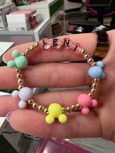 a person holding a beaded bracelet in their hand with the word teen written on it