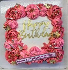 a birthday cake with pink frosting and gold decorations