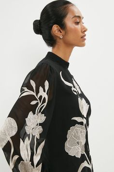 Elevated with intricate embroidery, this gauzy blouse makes an instant statement. Blouson sleeves accent a high neckline and gauzy finish, making it the perfect partner for high-rise tailored trousers and heels.Style: TopDesign: FloralFabric: GeorgetteLength: RegularNeckline: High NeckSleeve Length: Long Sleeve