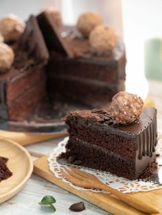 a piece of chocolate cake on a plate with a slice cut out and ready to be eaten