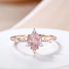 an engagement ring with a pink stone surrounded by white and rose gold diamonds on top