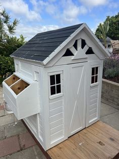 there is a small white shed with windows on the roof