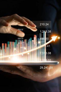 two hands holding a tablet with graphs on it