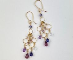 "Feel fabulous in these lovely royal jewel toned waterfall earrings! Purple and gold are the traditional colors of royalty.  These delicate dangles reach 2.5\" in length, but wear as light as a feather. Stones include iolite, moonstone, amethyst and garnet.  Earrings are made to order in my home studio, and may have slight variations in stone tones, as each stone is unique. Ships free, ready for gifting or enjoying." Jewel Tone Jewelry, Jewel Tones Jewelry, Chandelier Jewelry, Amethyst And Garnet, Waterfall Earrings, Lavender Earrings, Bleu Violet, Earrings Purple, Royal Jewels