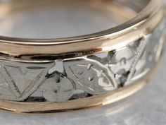 a close up view of a wedding ring with flowers on the side and leaves on the inside