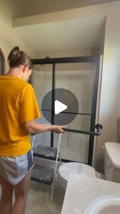 a woman standing in front of a shower door