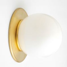 a light that is on the side of a white wall with a gold trim around it