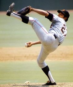 a baseball player pitching a ball on top of a field