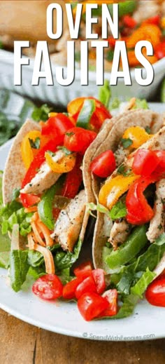 two chicken fajitas on a plate with lettuce and tomatoes