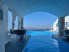 an outdoor swimming pool with chairs and tables next to it