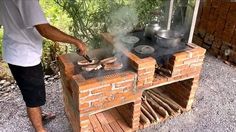 a man cooking food on an outdoor brick grill