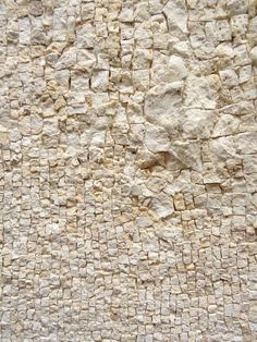 a stone wall with small rocks on it