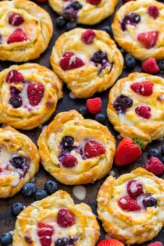 berries and cream puff pastry on a baking sheet with strawberries, blueberries and raspberries