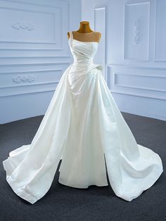 a white wedding dress on display in a room