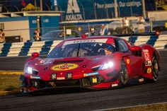 a red sports car driving on a race track