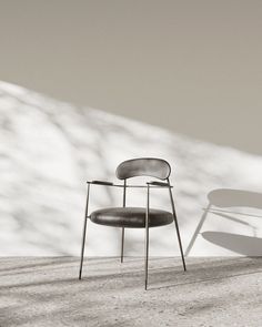 a chair sitting on top of a cement floor next to a snow covered mountain side