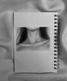 a black and white photo of a woman's face on a spiral bound notebook