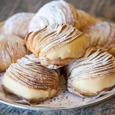 several pastries are on a plate with powdered sugar