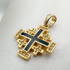 Immerse yourself in divine elegance with our 14k Gold Jerusalem Cross Pendant, adorned with Black Enamel and Zircons, a harmonious blend of spiritual significance and exquisite craftsmanship. 🌟 Meaning of the Jerusalem Cross: The Jerusalem Cross, with its distinctive design featuring four smaller crosses surrounding a central one, holds deep religious symbolism. Each arm represents the foundational Christian virtues of faith, hope, love, and the central message of the Gospel. ⛪️ Pointing to the Black Symbolic Jewelry For Anniversary, Black Symbolic Anniversary Jewelry, Symbolic Black Jewelry For Anniversary, Black 14k Stamped Jewelry As Gift, Traditional Black Jewelry For Anniversary, Black 14k Stamped Jewelry For Gift, Traditional Black Jewelry With Polished Finish, Traditional Black Hallmarked Jewelry, Traditional Gold Jewelry With Black Enamel