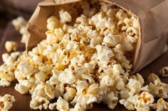 a brown paper bag filled with popcorn on top of a wooden table