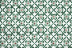 a green and white pattern with red dots on the center is shown in this image