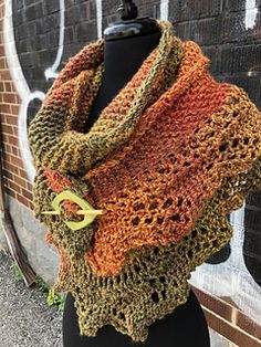 a woman's scarf on a mannequin with an orange and green crochet