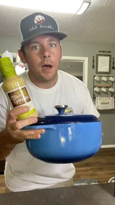 a man holding a blue bowl with mustard and ketchup in it