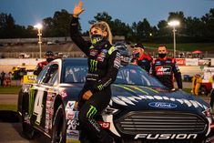 a woman waves to the crowd from her car