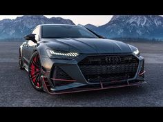 the front end of an audi car with red rims and black paint on it