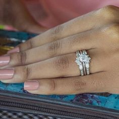 a close up of a person's hand with two rings on their fingers