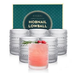 four glasses filled with pink liquid next to a box of hobnall lowball