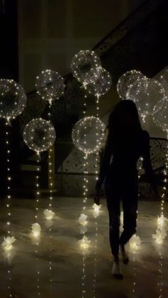 a woman walking down a street covered in lights