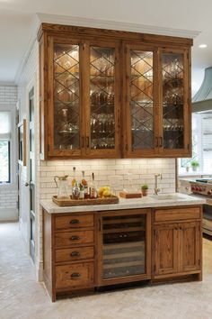 a kitchen with wooden cabinets and marble counter tops, along with white tile flooring