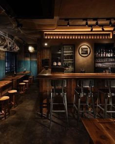 an empty bar with stools and wooden tables