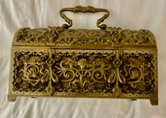 an ornately decorated gold box on a white background