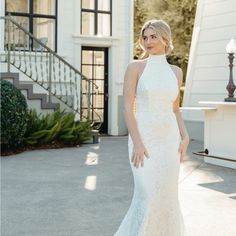 a woman in a white wedding dress posing for a photo outside her house with stairs