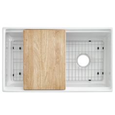 a white sink with a wooden cutting board in the middle and grids on the bottom