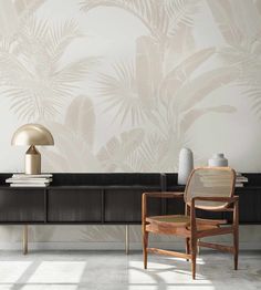 a chair and table in front of a wall with palm leaves on it