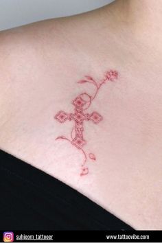 a woman with a tattoo on her chest has a cross in the middle of it