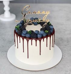 a birthday cake with berries and chocolate drizzled on the top is shown