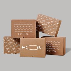 four boxes with fish on them sitting next to each other in front of a gray background