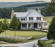 a large white house sitting on top of a lush green field