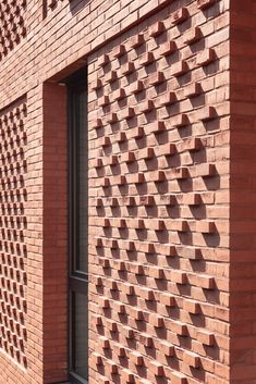 the corner of a brick building with an intricate pattern on it's side wall