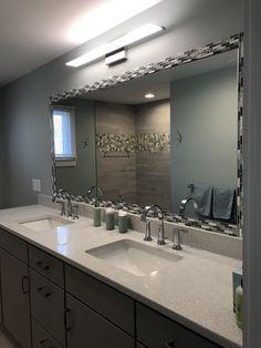 a bathroom with two sinks and a large mirror over it's sink area,