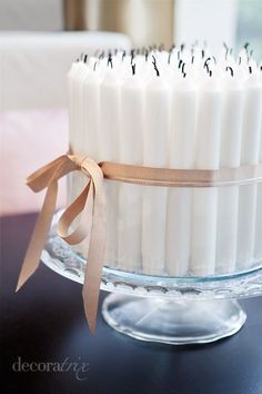 a cake with white candles and brown ribbons