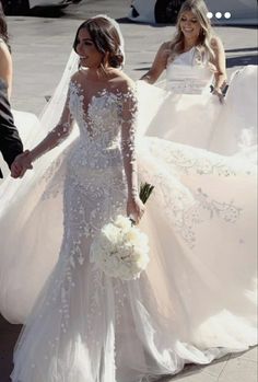 the bride and groom are walking down the street with their wedding gowns in hand