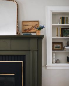 a living room with a fire place and bookshelves on the wall next to it